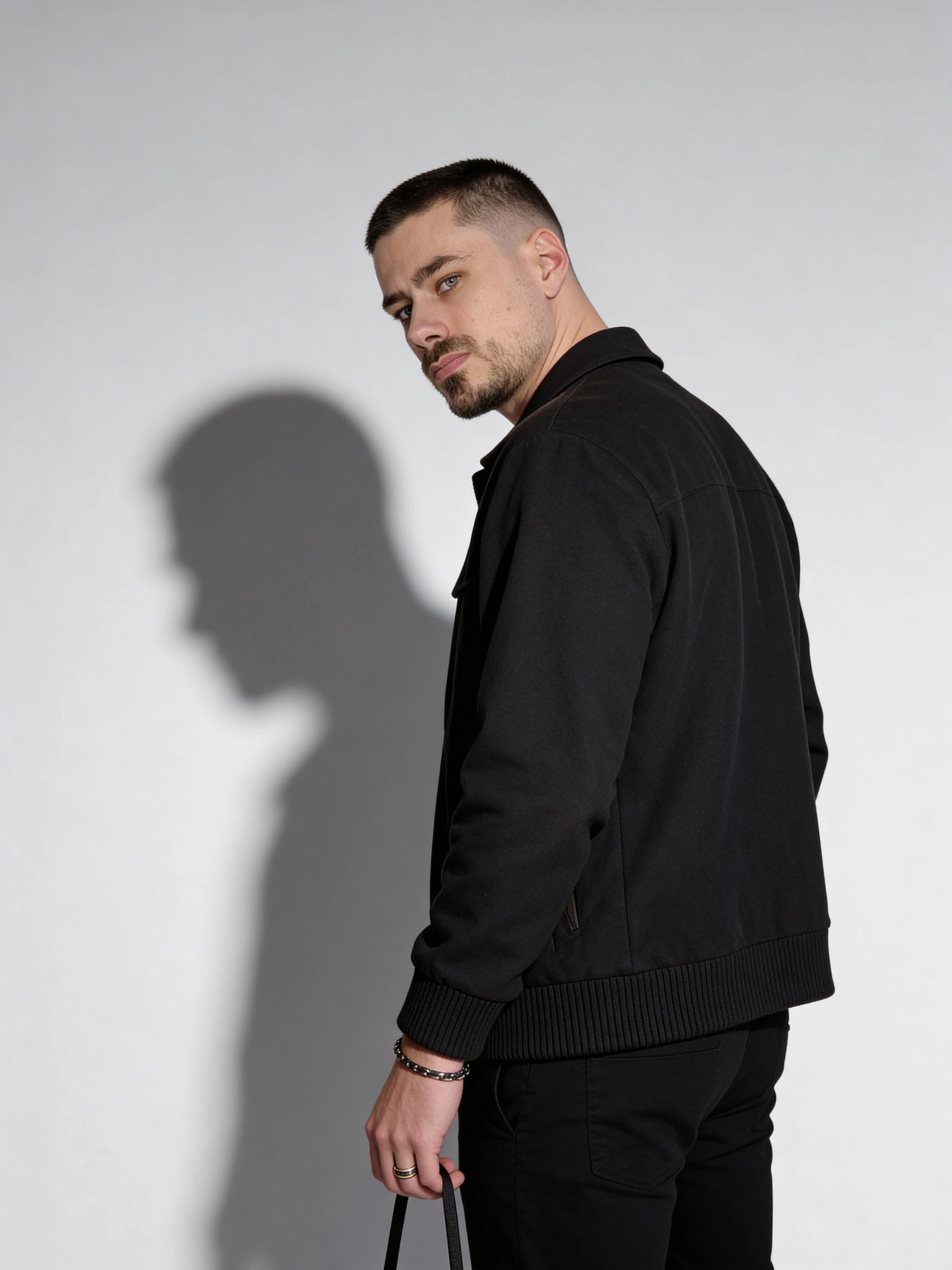 Fotorealistischer männlicher Digitaler Zwilling im schwarzen Outfit mit Schattenwurf, Studio Porträt, Trickhouse KI-Model-Agentur