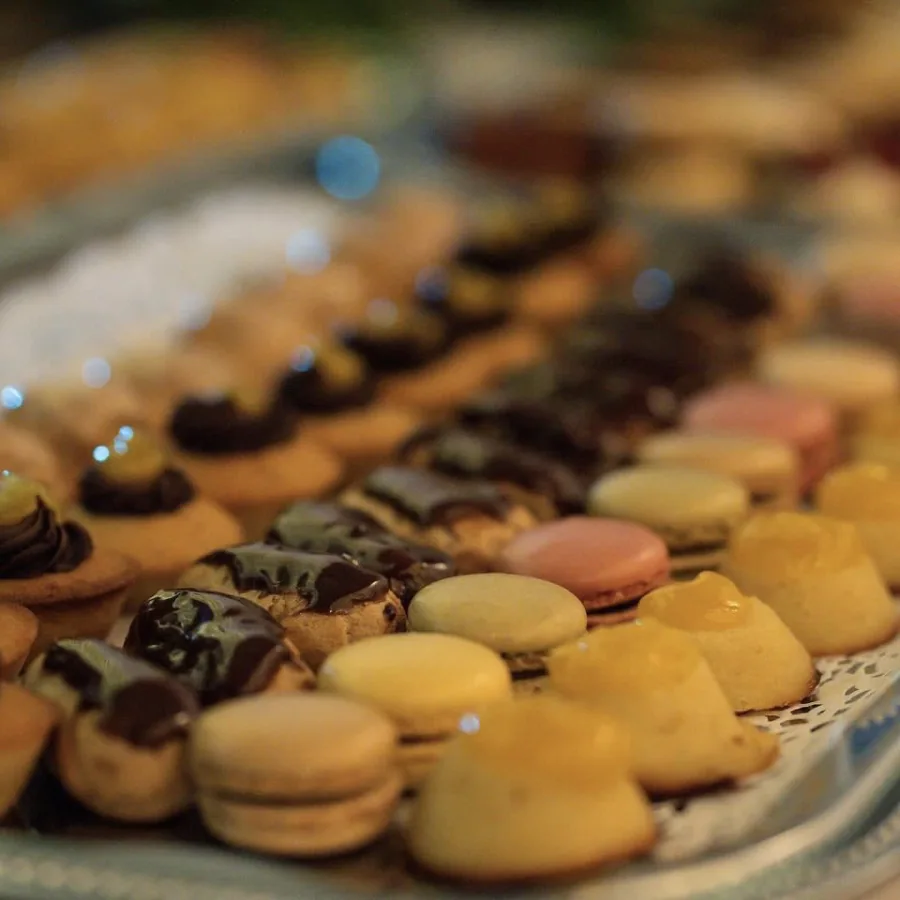 Plateau de mignardises sucrées avec macarons multicolores, choux à la crème et petits fours alignés pour un brunch gourmand.