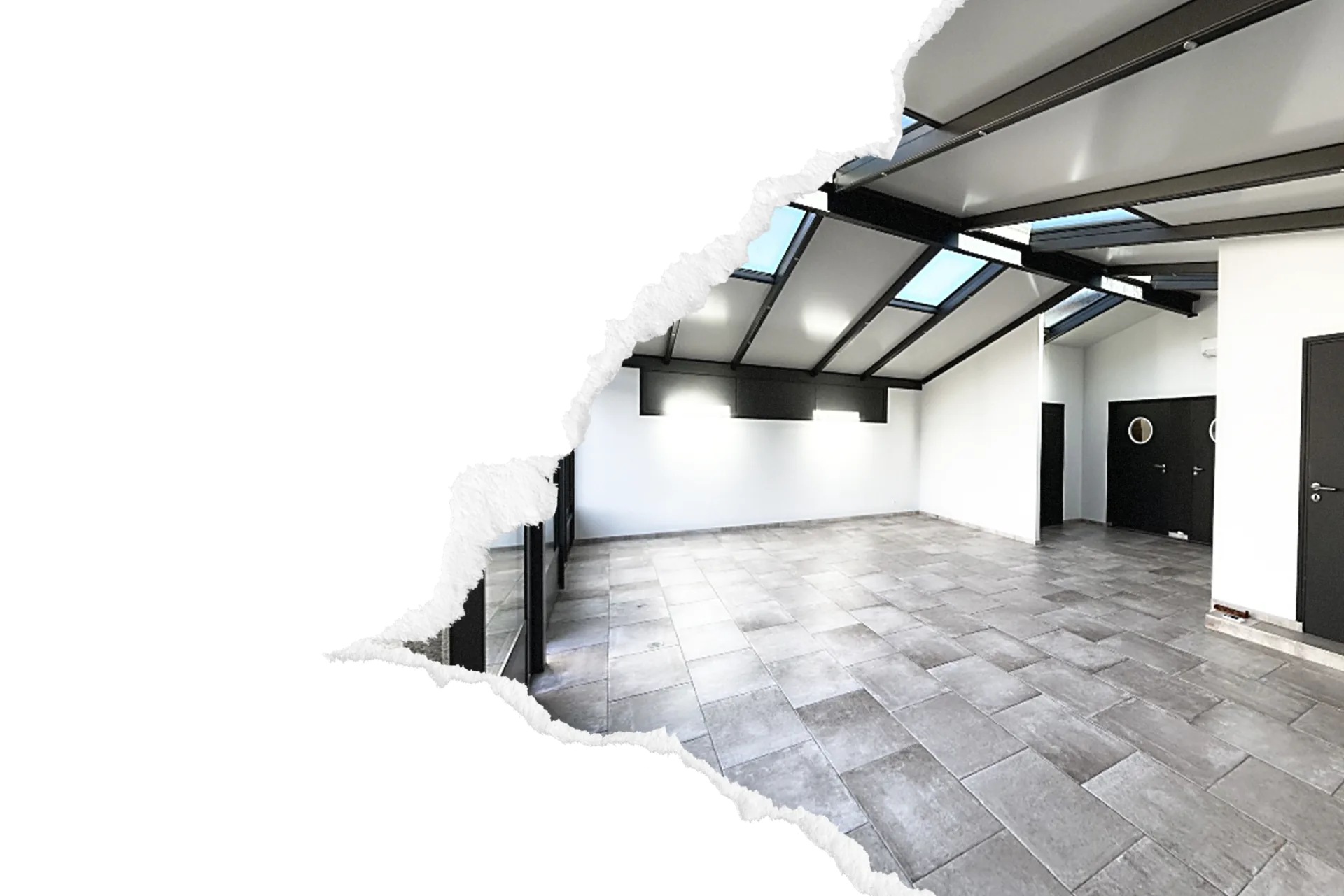 Salle de reception vide a l'esprit industriel avec verriere au plafond, sol carrele gris et murs blancs, prete a etre amenagee pour un evenement a Evreux.