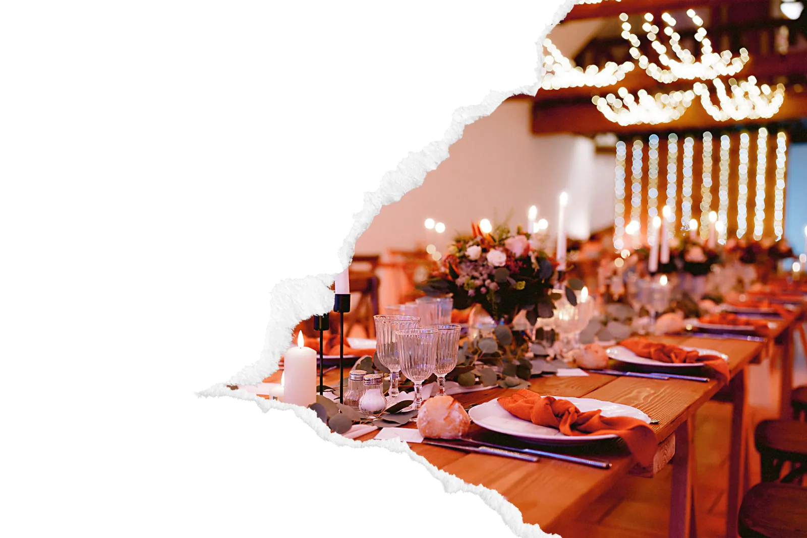 Table de mariage dressee en longueur sous un lustre lumineux, decoree de bougies, serviettes orangees et bouquets floraux pour une reception intime en interieur. Image avec bord dechire decoratif.