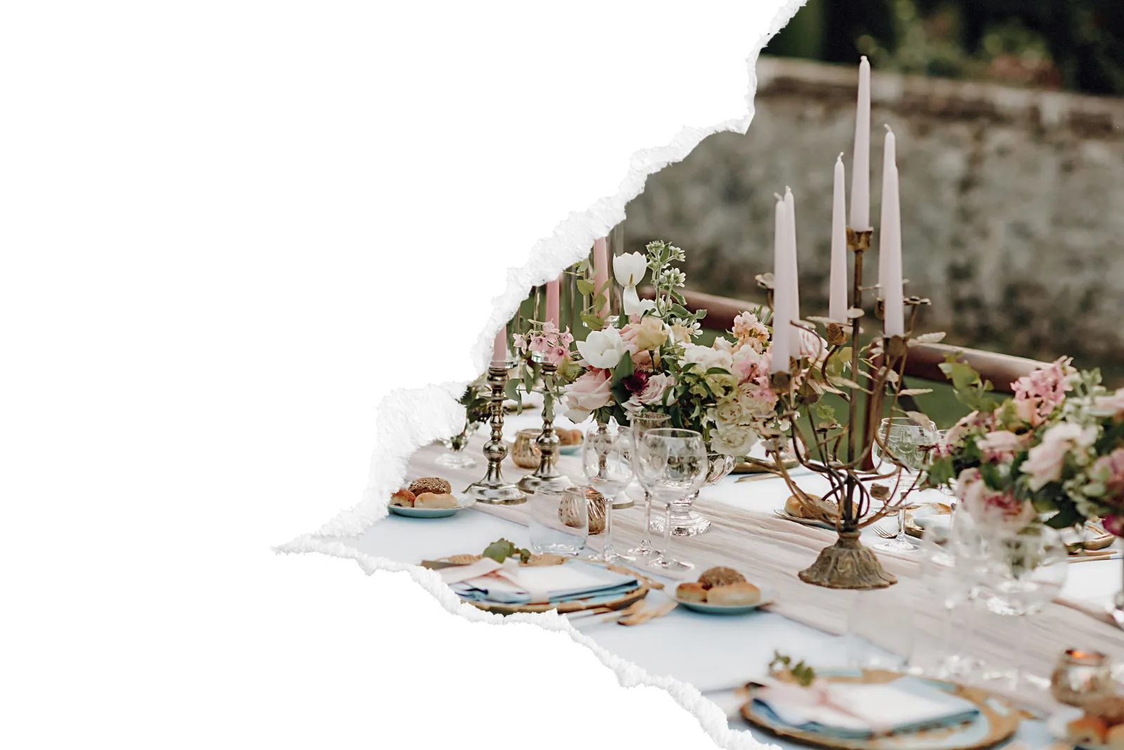 Table de mariage dressee en exterieur avec chandeliers dores, bouquets de fleurs roses et blanches, assiettes et verres en cristal pour une reception elegante dans la zone de Gaillon.