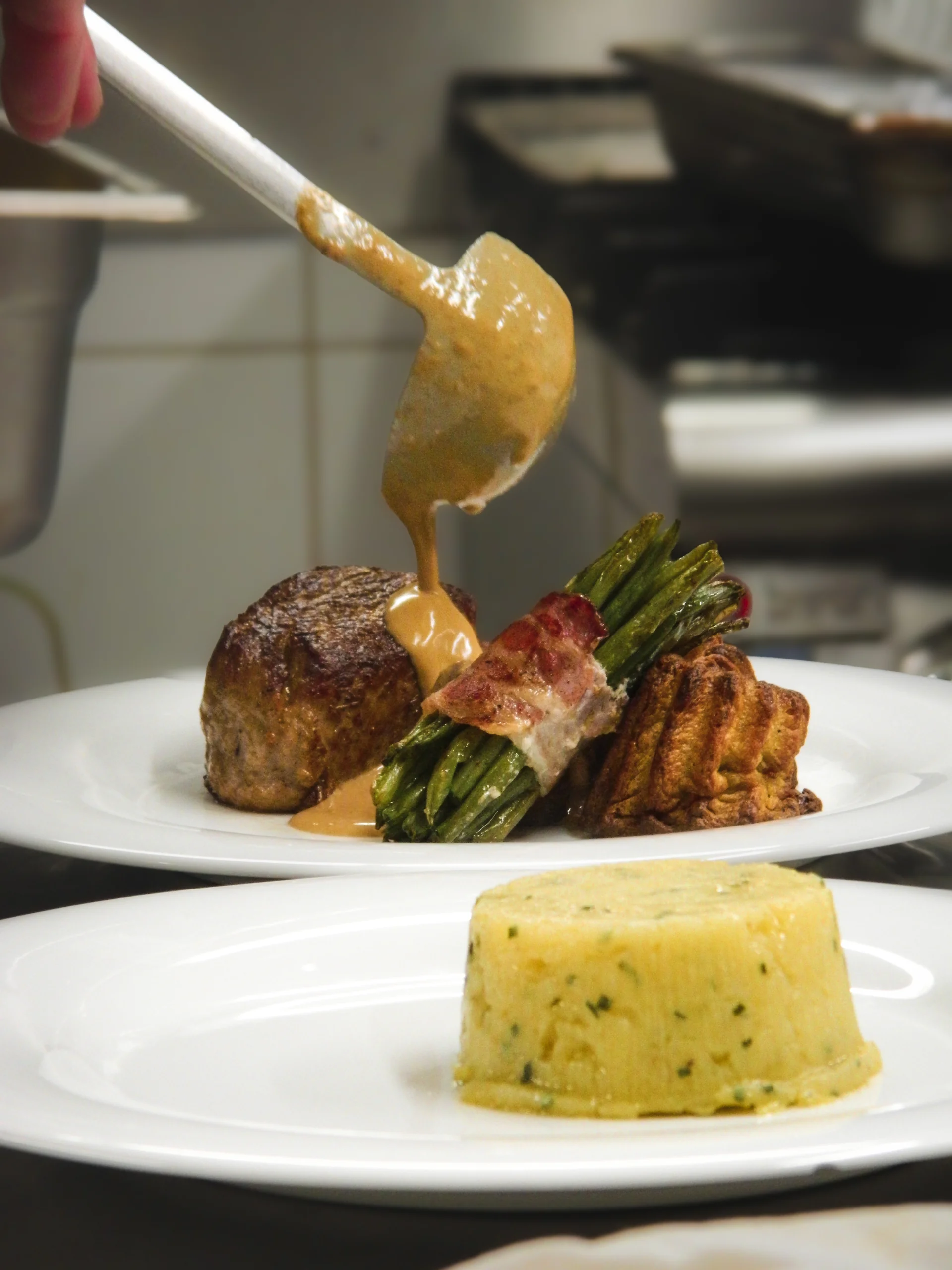 Nappage minute d'une sauce onctueuse sur un filet de bœuf accompagné d'un fagot de haricots verts au lard et d'une pomme darphin — savoir-faire en cuisine À Votre Goût.