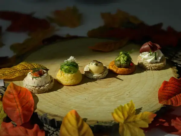 Cocktail dînatoire A Votre Goût — canapés et verrines automnaux sur planche de bois.