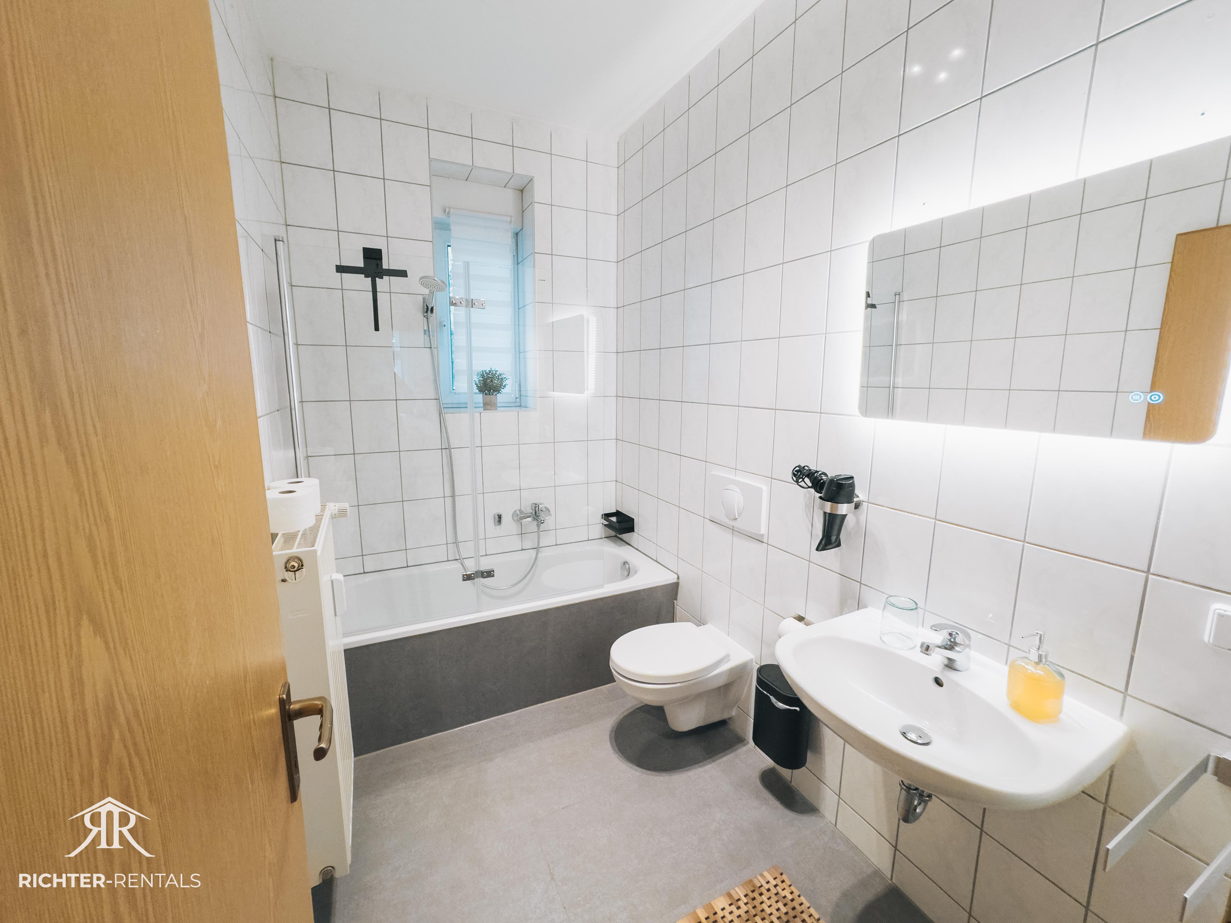 Badezimmer mit Badewanne und Duschwand