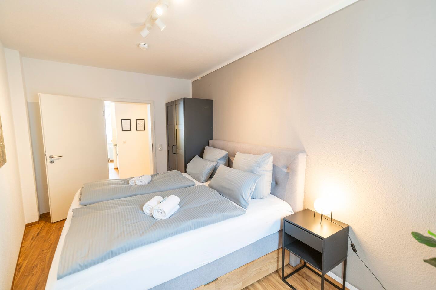 Bedroom with large king-size double bed, wardrobe & bedside table
