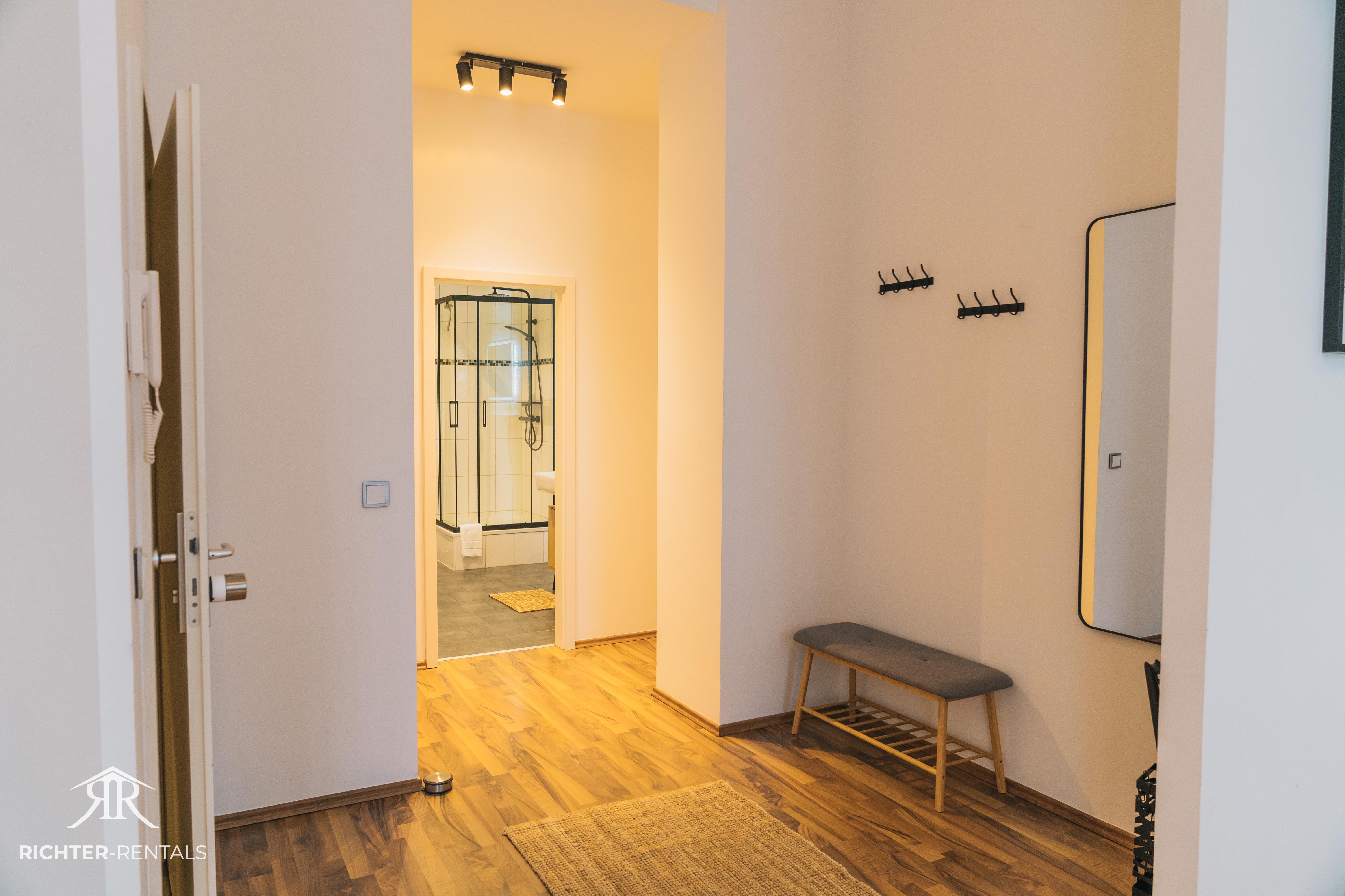 Modern entrance area with wardrobe, bench & large mirror