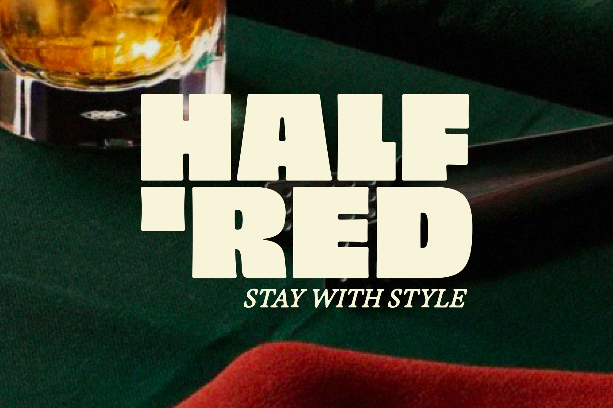 Verre de whisky sur table verte avec pipe et texte Half Red Stay With Style.