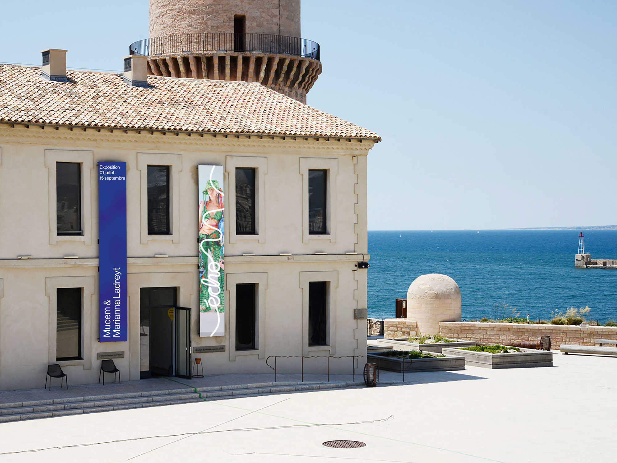Façade d'un bâtiment avec affiches d'exposition Mucem & Marianna Ladreyt, vue sur la mer Méditerranée en arrière-plan.