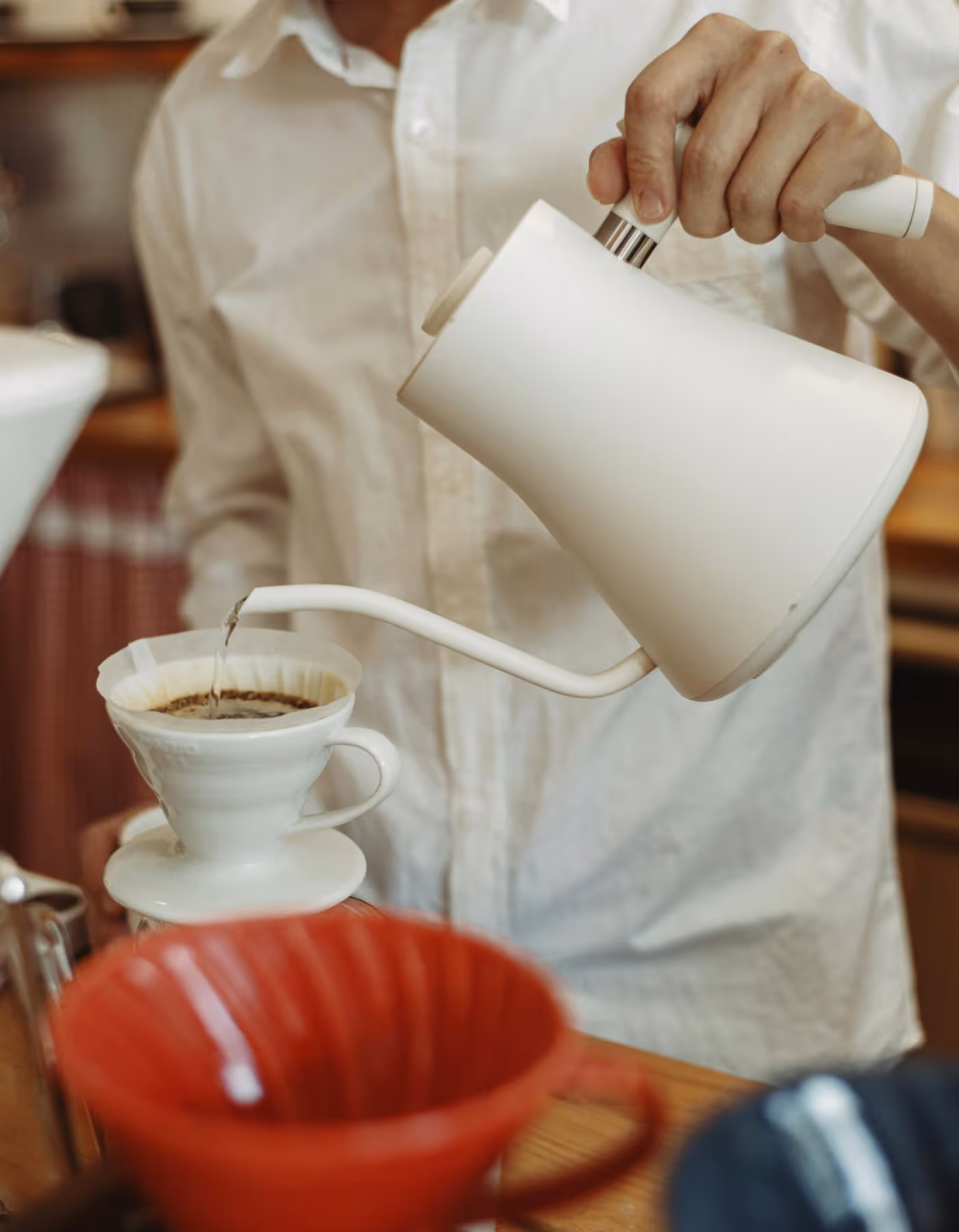 Barista expertly pouring coffee with a gooseneck kettle