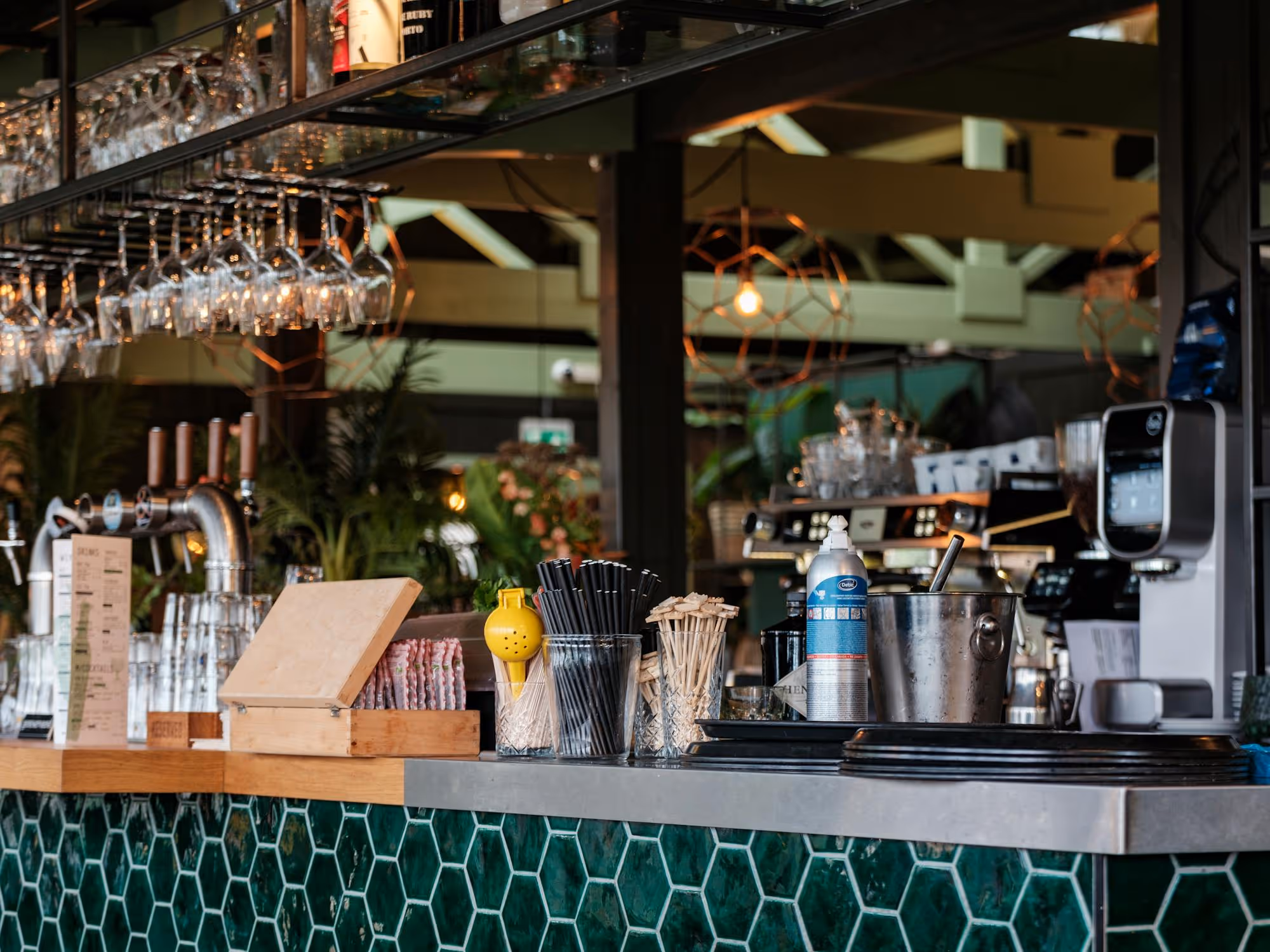 Modern cafe counter with hanging glassware and espresso machines