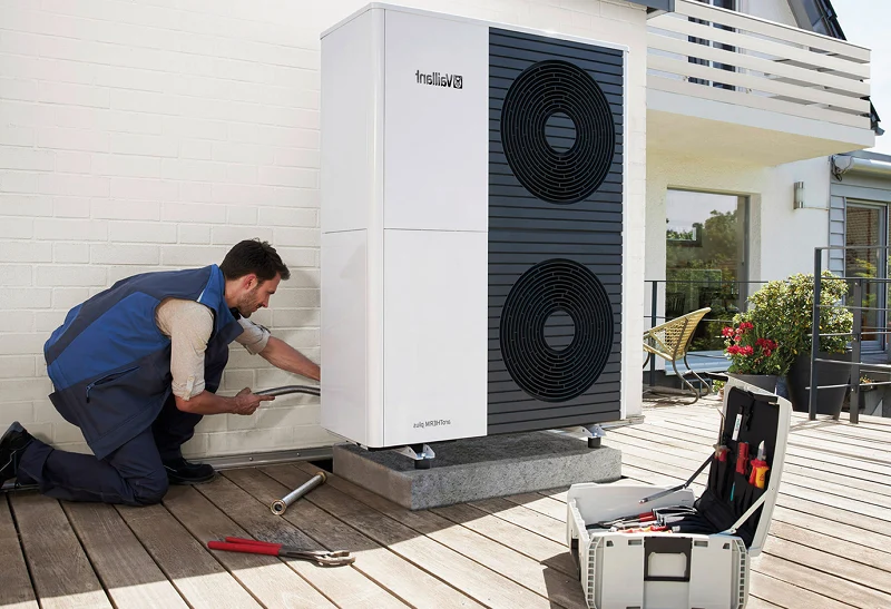 Tres trabajadores con cascos instalando paneles solares en una estructura metálica al aire libre.