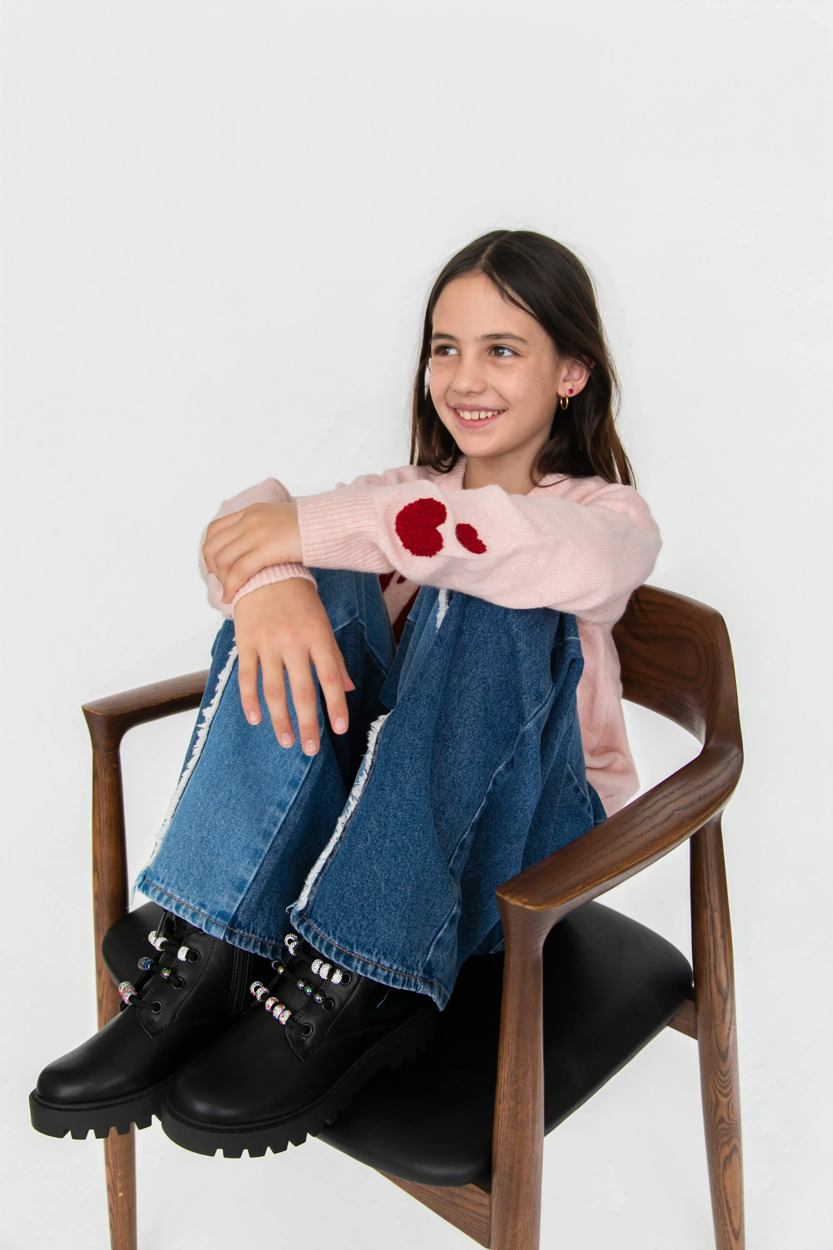 A girl sitting in a chair with her legs crossed.