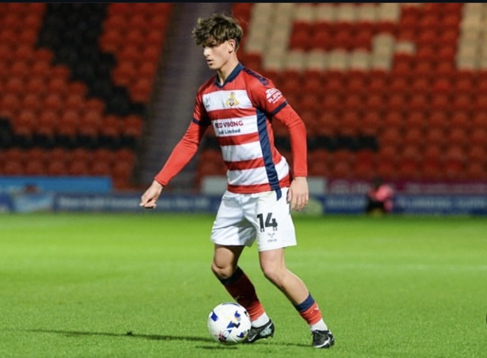 Young footballer on the ball in a stadium
