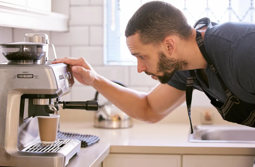 `Technician inspecting an espresso machine in a home kitchen`