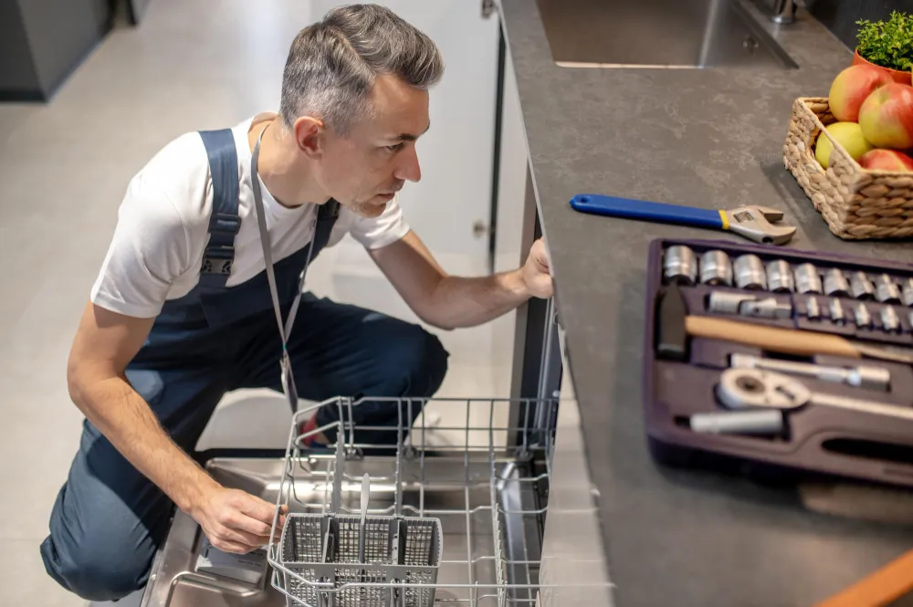 Appliance repair technician servicing a residential dishwasher