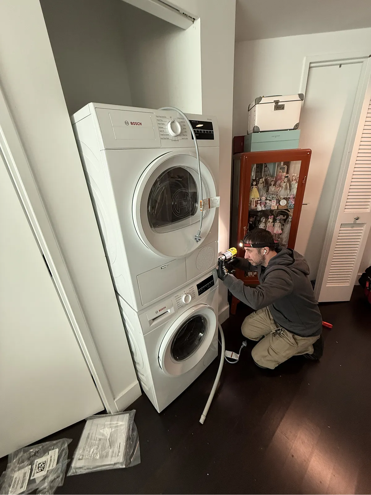 ProFix technician repairing a stacked Bosch washer and dryer unit in a Bridgewater NJ home