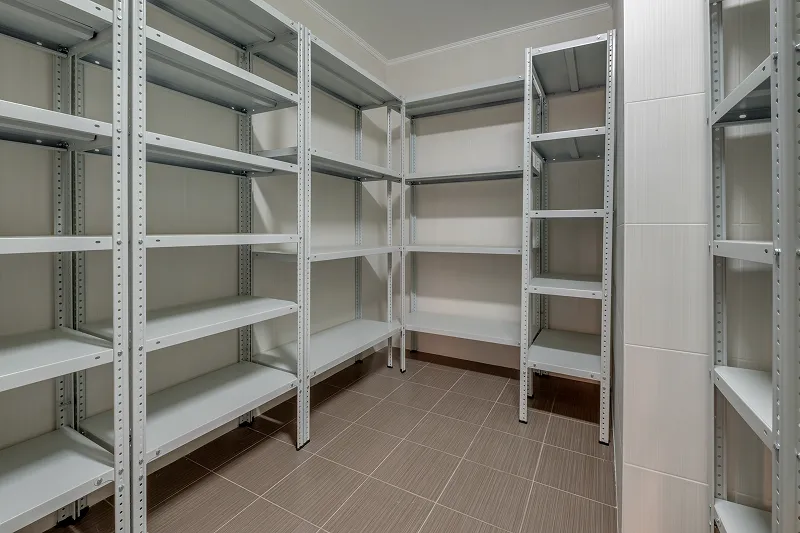 Empty metal shelving inside a commercial walk-in refrigerator