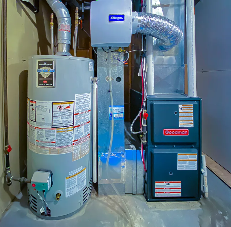 Goodman furnace with ductwork in a basement utility area.