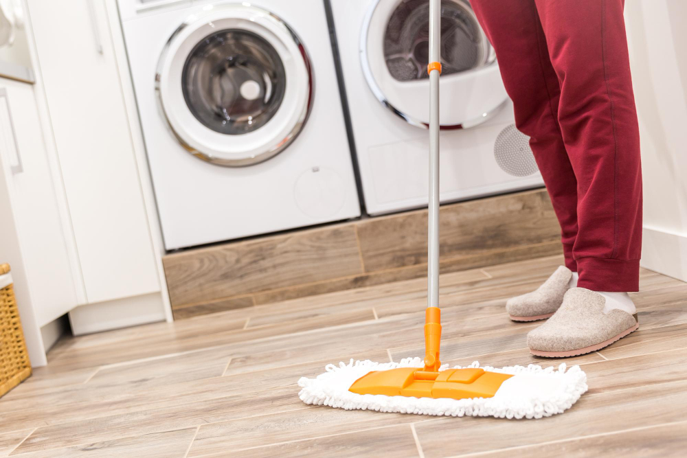 Pperson cleaning floor because washer is leaking