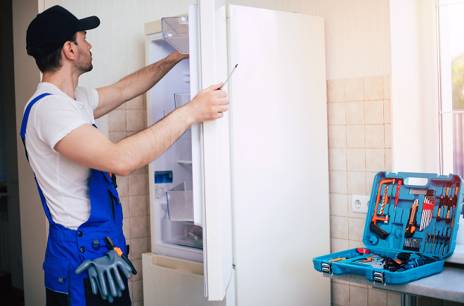Professional young repairman in worker uniform and cap with modern toolbox with equip