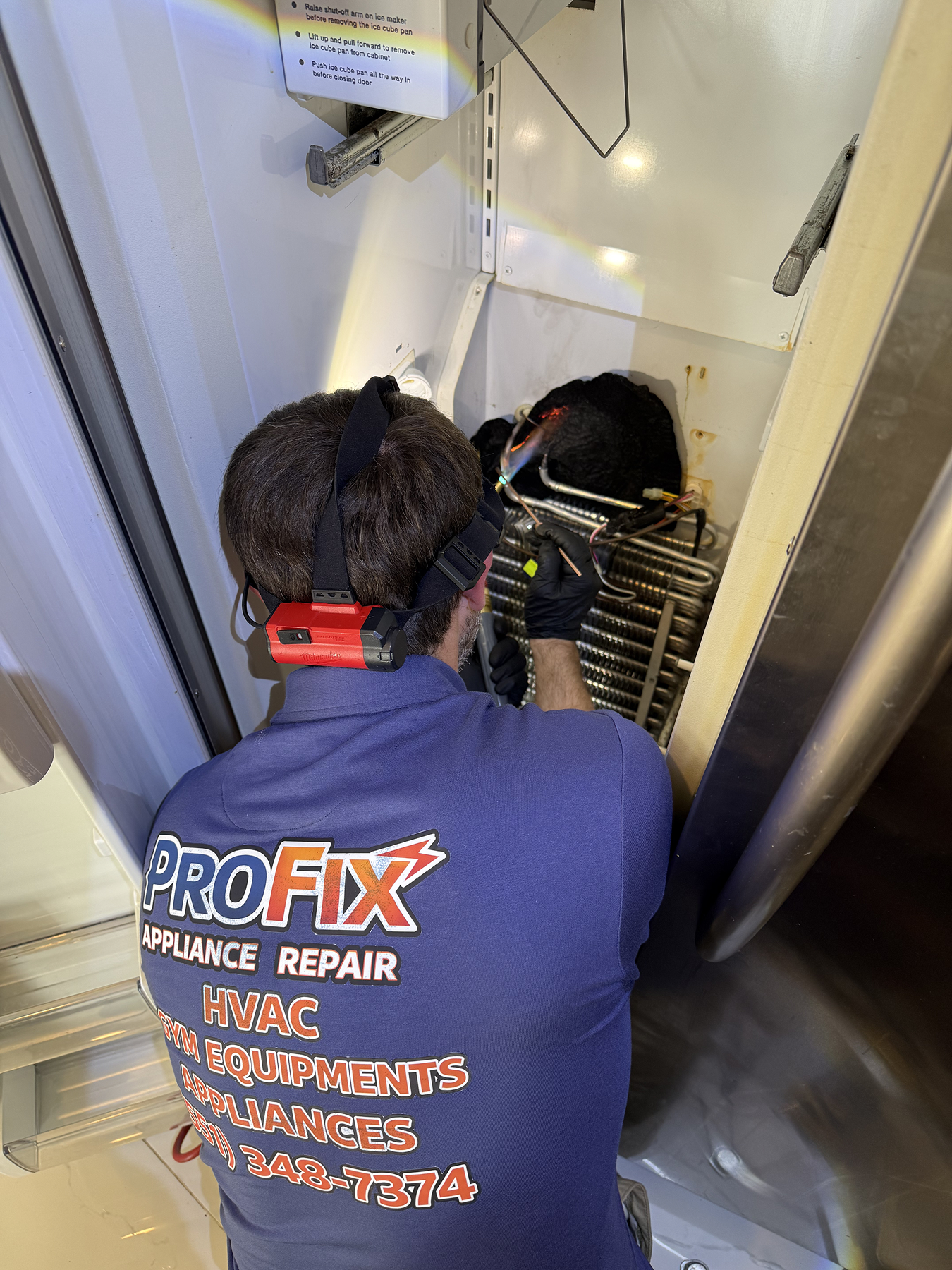 pro fix technician repairing refrigerator