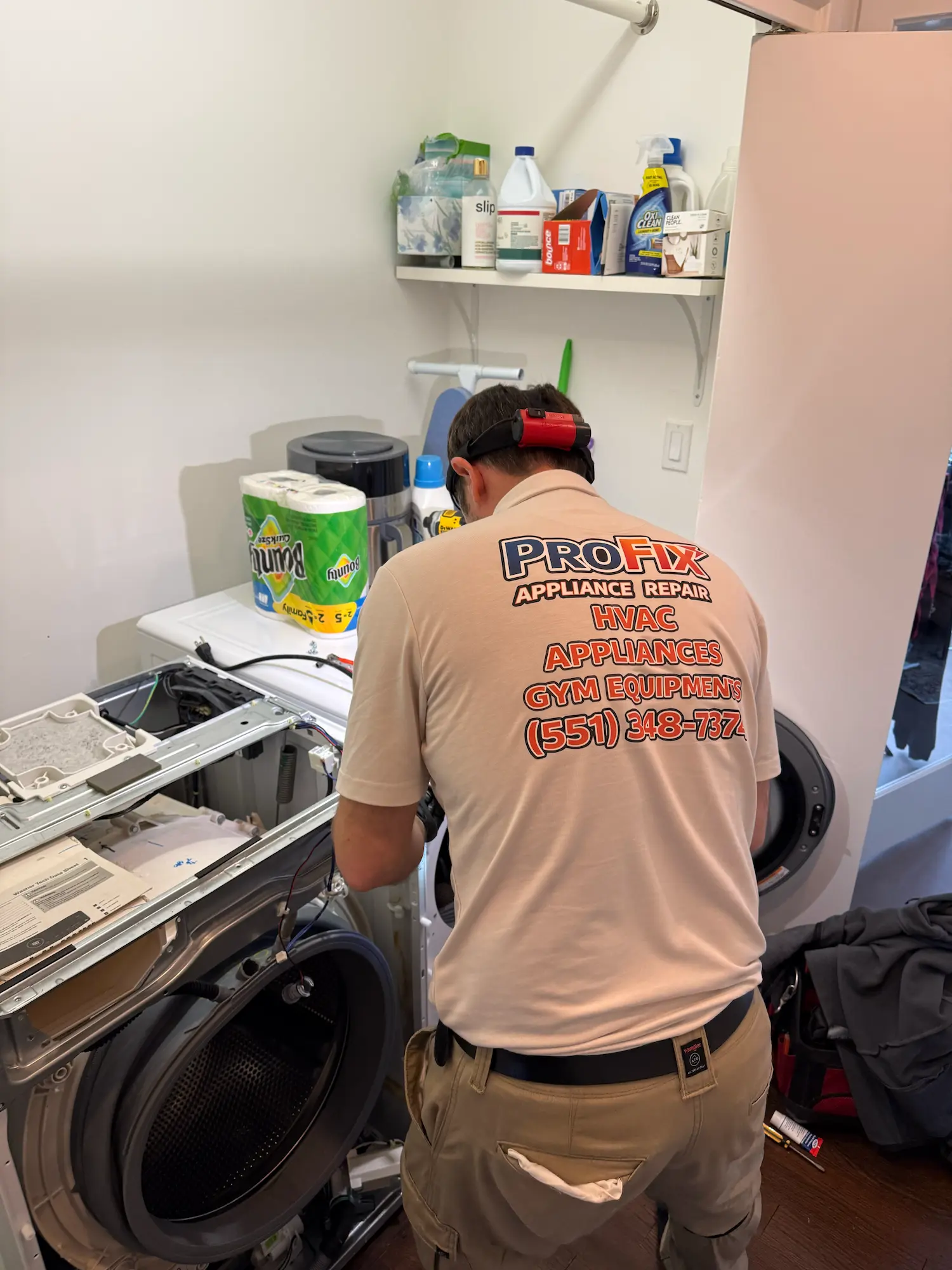 ProFix technician repairing a front-load washer in a residential laundry room in NJ