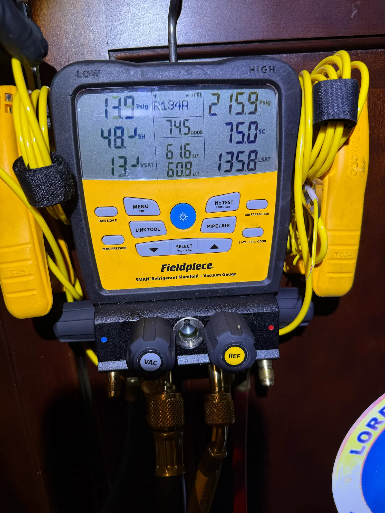 ProFix technician using a Fieldpiece refrigerant manifold gauge during appliance diagnostic