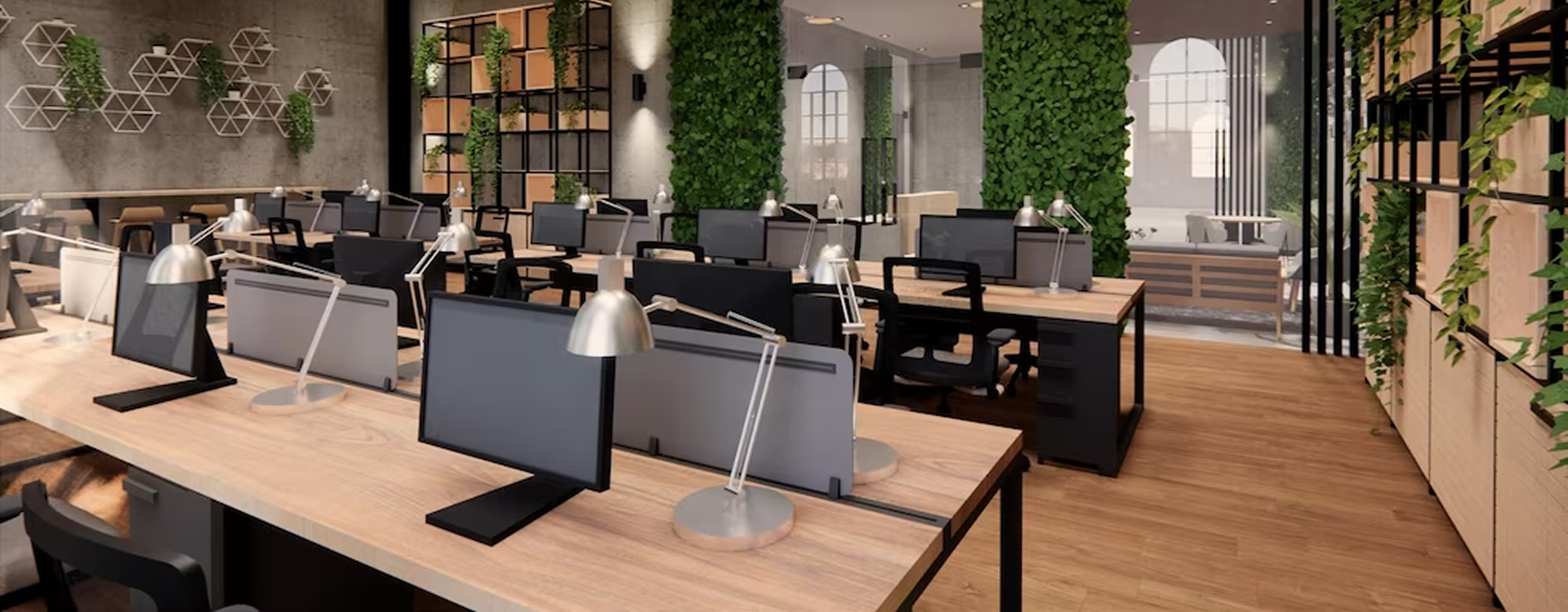 Modern open-plan office with wooden desks, multiple computer monitors, task lamps, black office chairs, and green vertical plant walls.