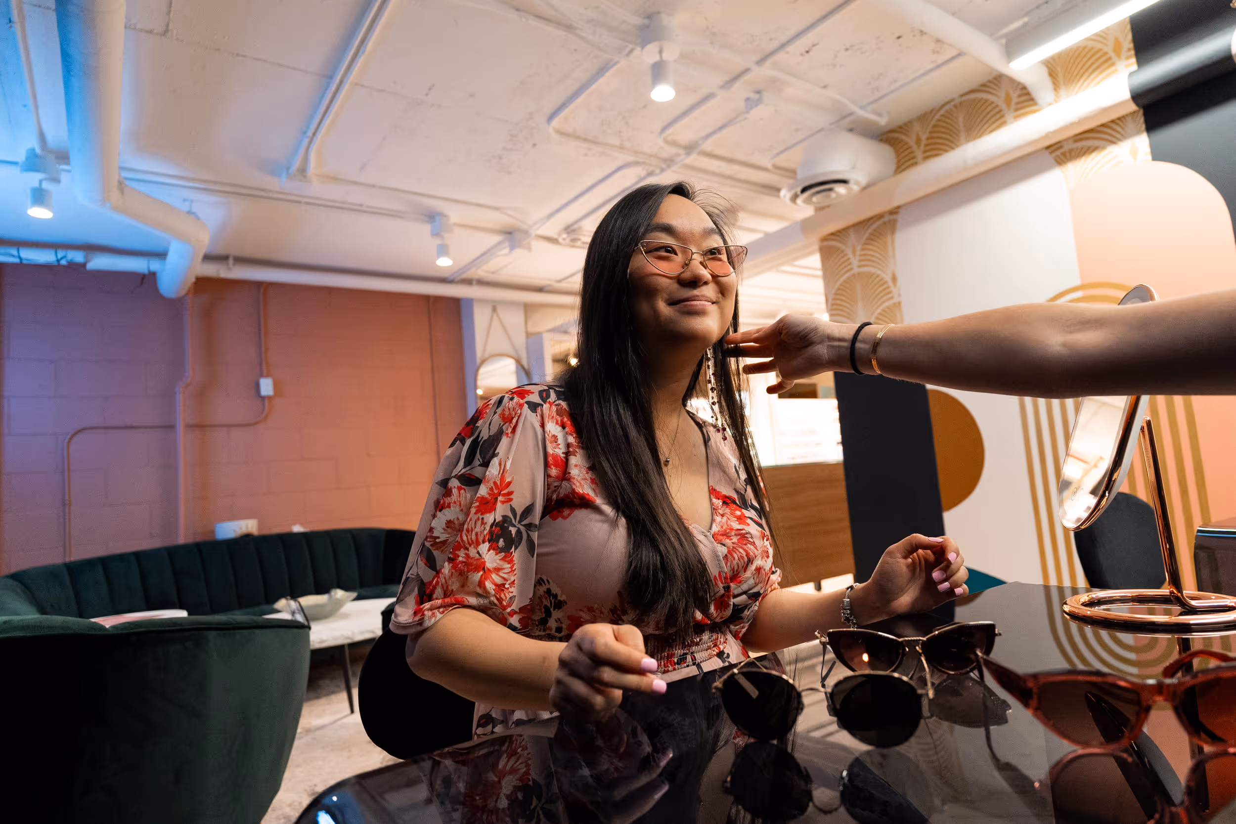 Person trying on different pairs of sunglasses at The Vault in Vision Care Wellington