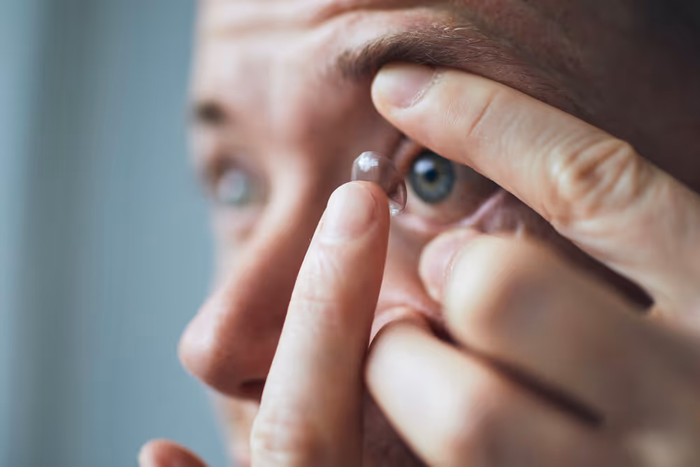 Disposable Contact Lenses. Man putting contact lens in eye.