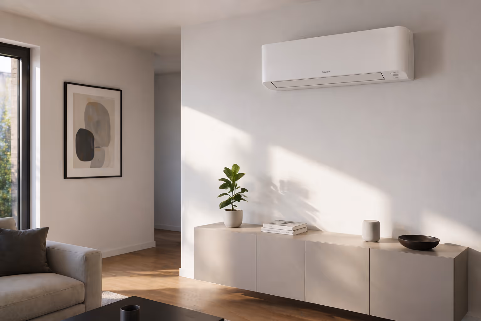 Moderner Wohnbereich mit einer weißen Klimaanlage an der Wand, einer Kommode mit einer Pflanze, Büchern und Dekorationsgegenständen.