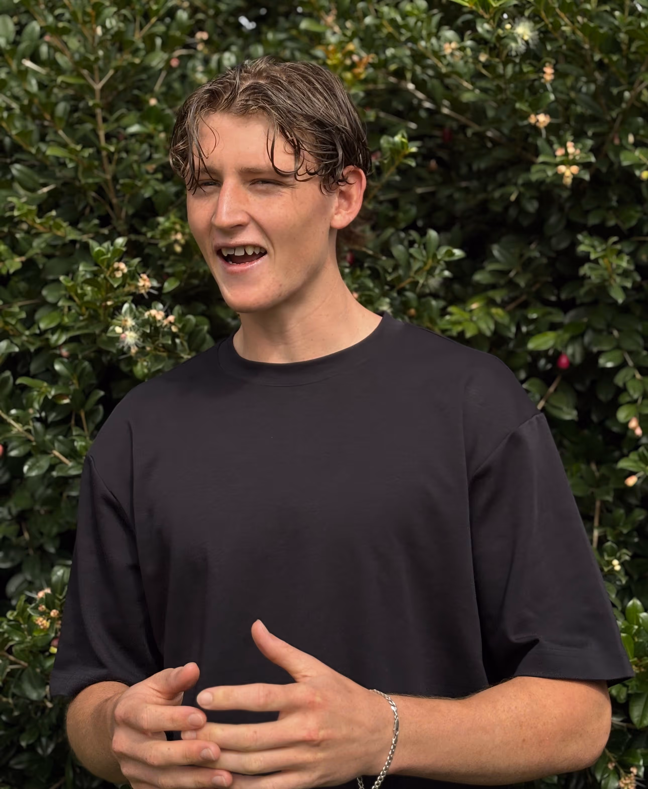 Oak Jardi Tupman Perth freelance web designer smiling and speaking candidly outdoors with green garden background