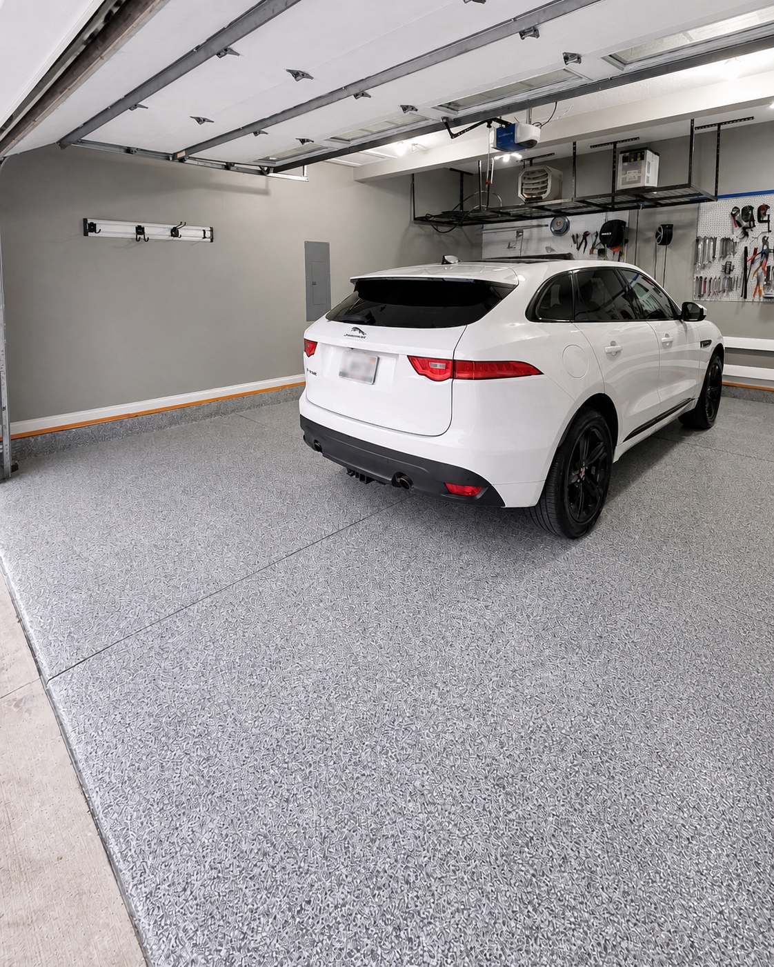 Completed EverForge flake flooring system with a white vehicle in a finished residential garage