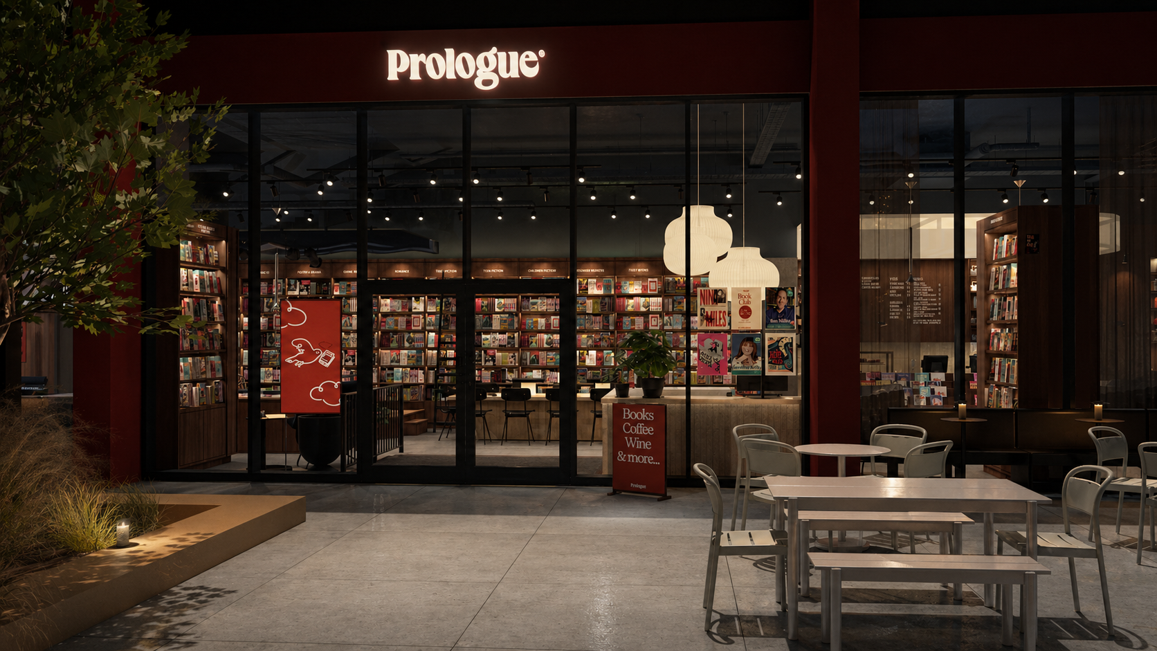 Night view of Prologue bookstore in Stockport with bookshelves, seating inside, and outdoor tables and chairs.