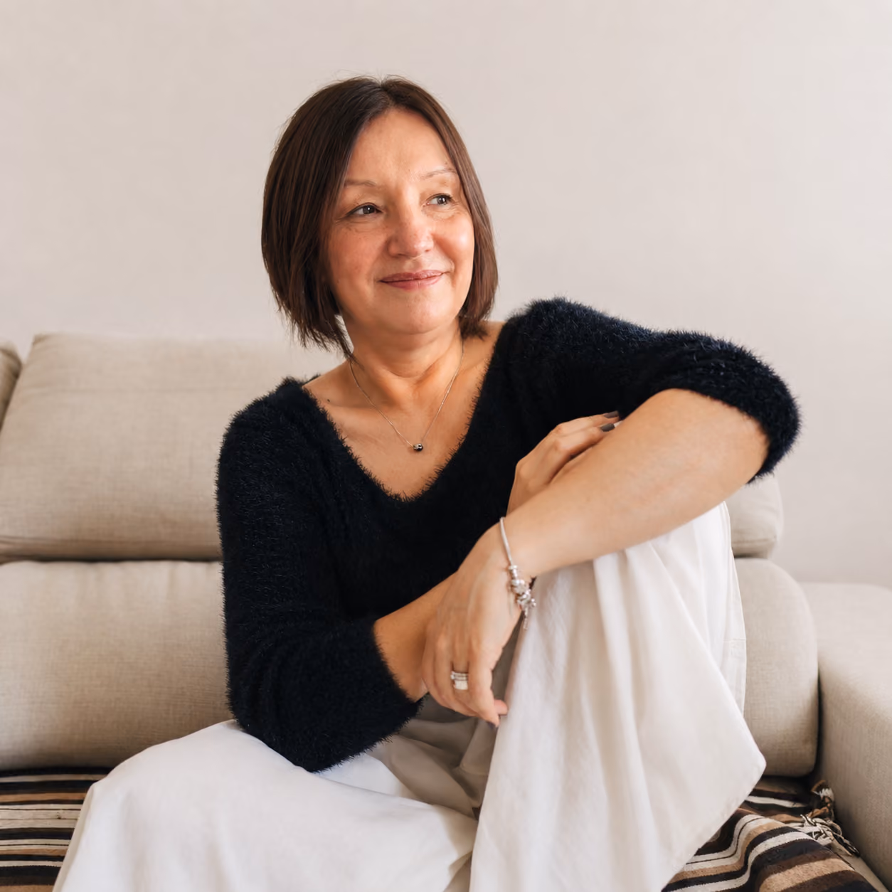 Ewa Mikrut, expressive arts therapist, sitting in a calm, welcoming therapy space.