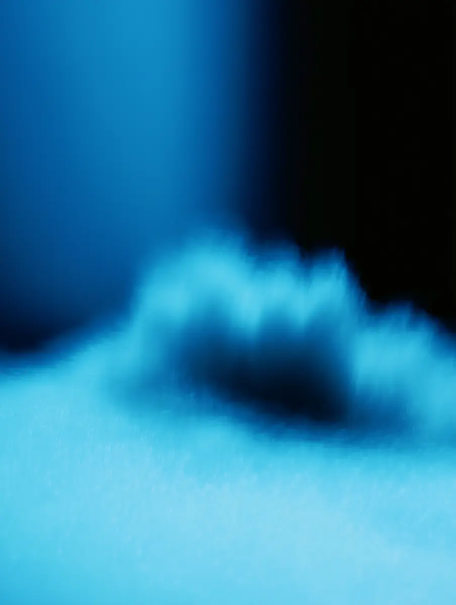 Close-up of a sleek black electronic device with a glossy surface and circular buttons in a row.