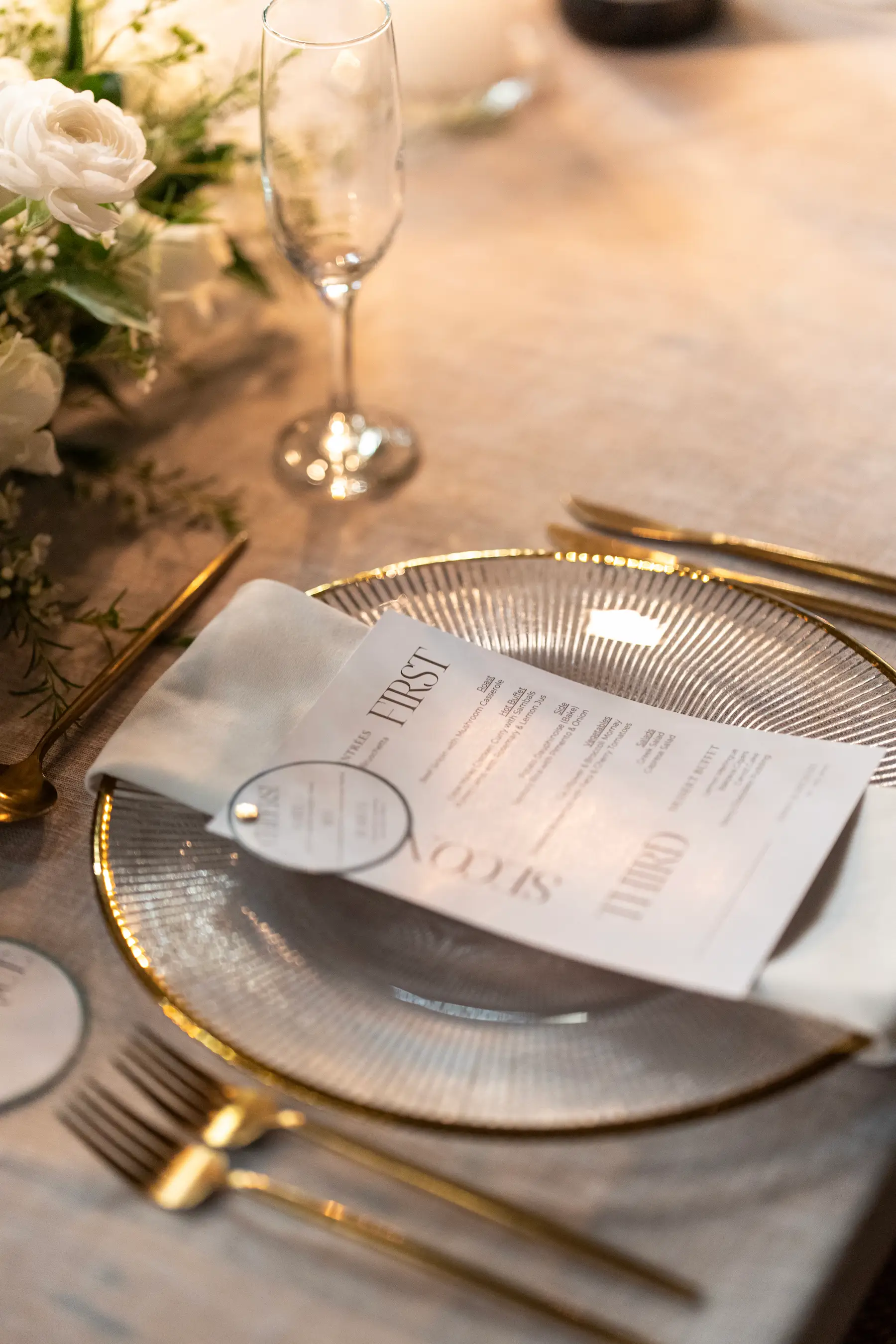 A detail image of a wedding reception menu a top a dinner plate.
