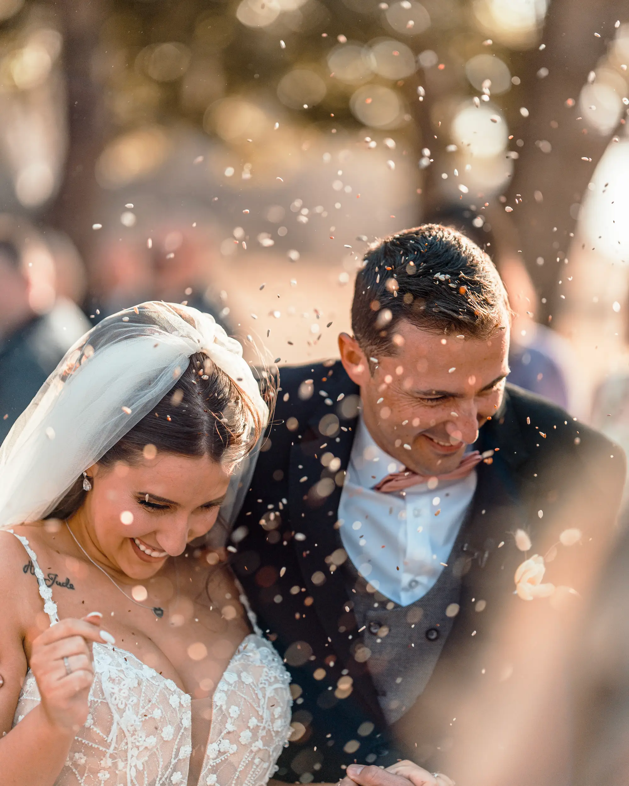 A newly wed couple moving through a cheering crowd.