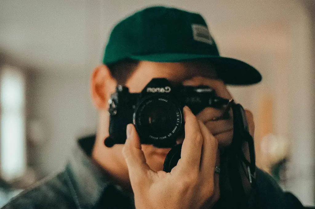 A closeup shot of a photographer with a camera taking a picture