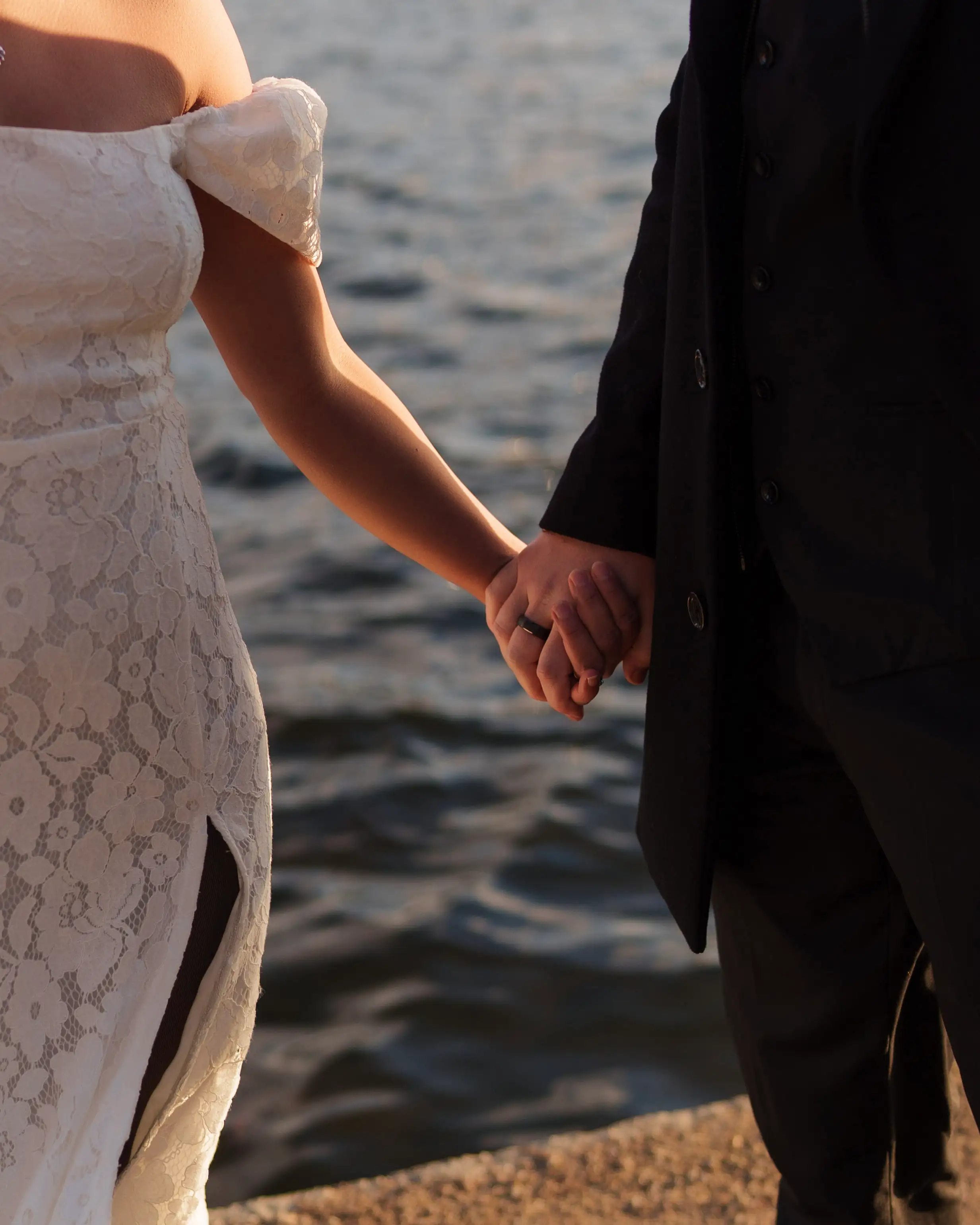 Bride and groom holding hands by the canal waters