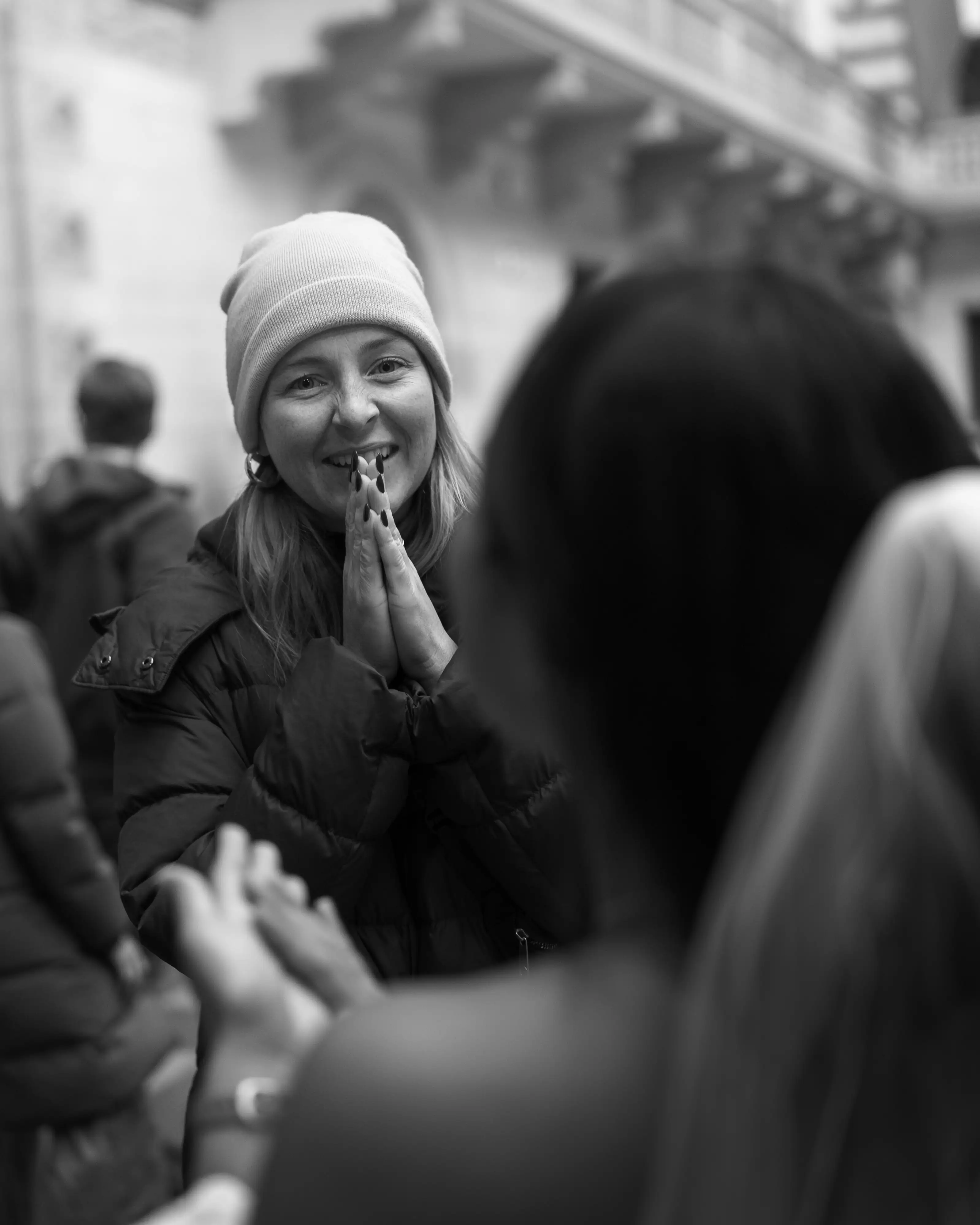 Wedding guests greeting and chatting in a courtyard, wearing winter clothing