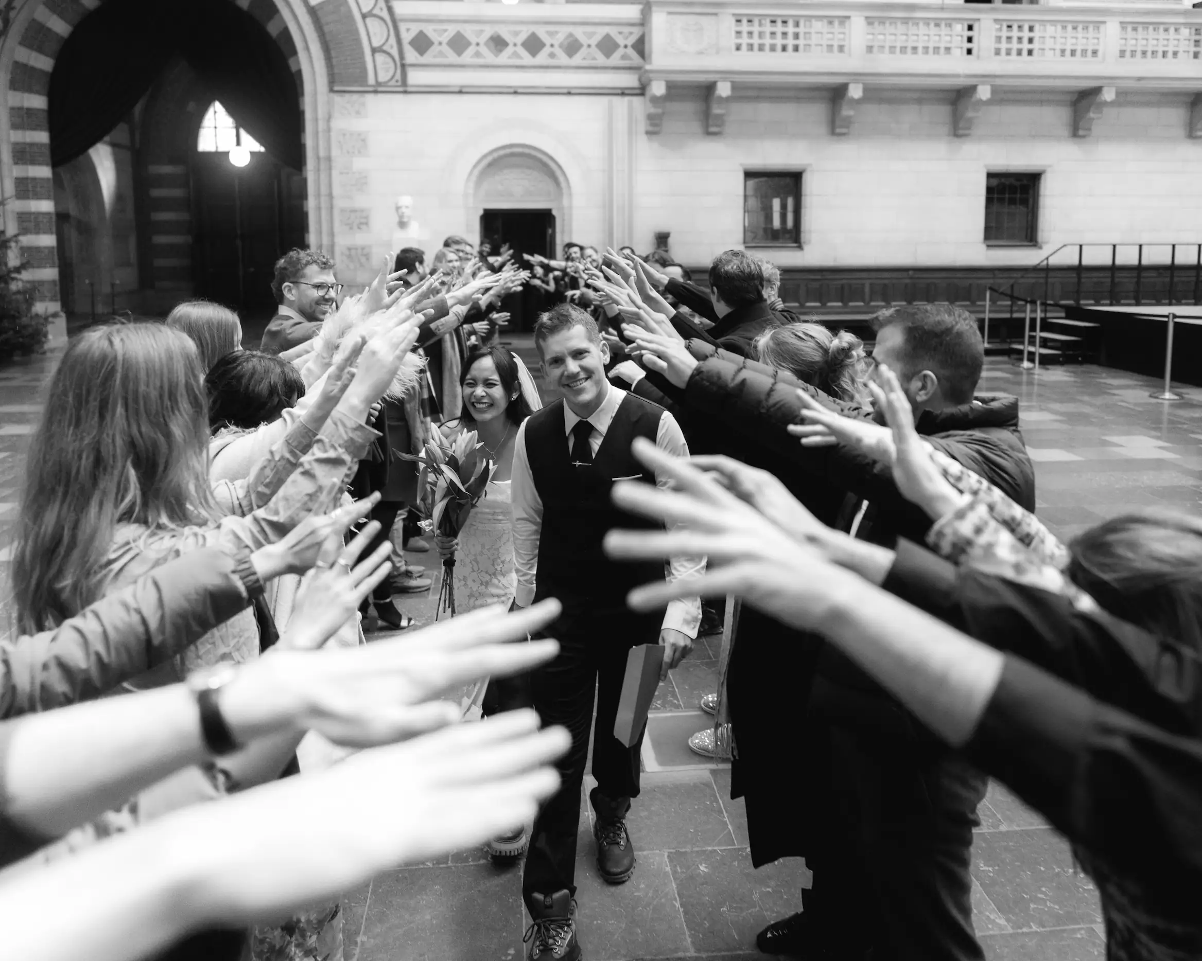 Newlyeds walking through a crowd of wedding guests