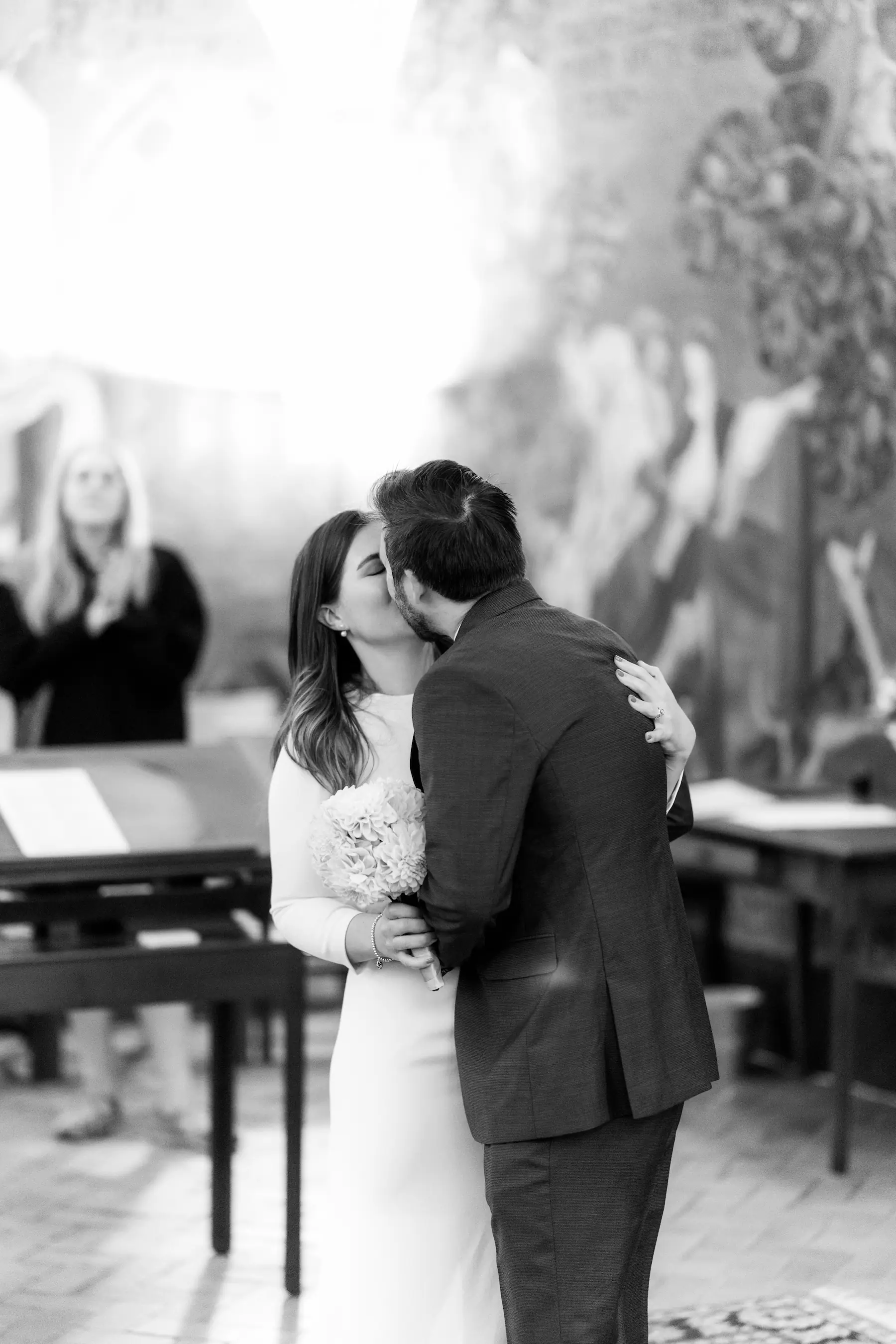 Black and white image of a bride and groom kissing.