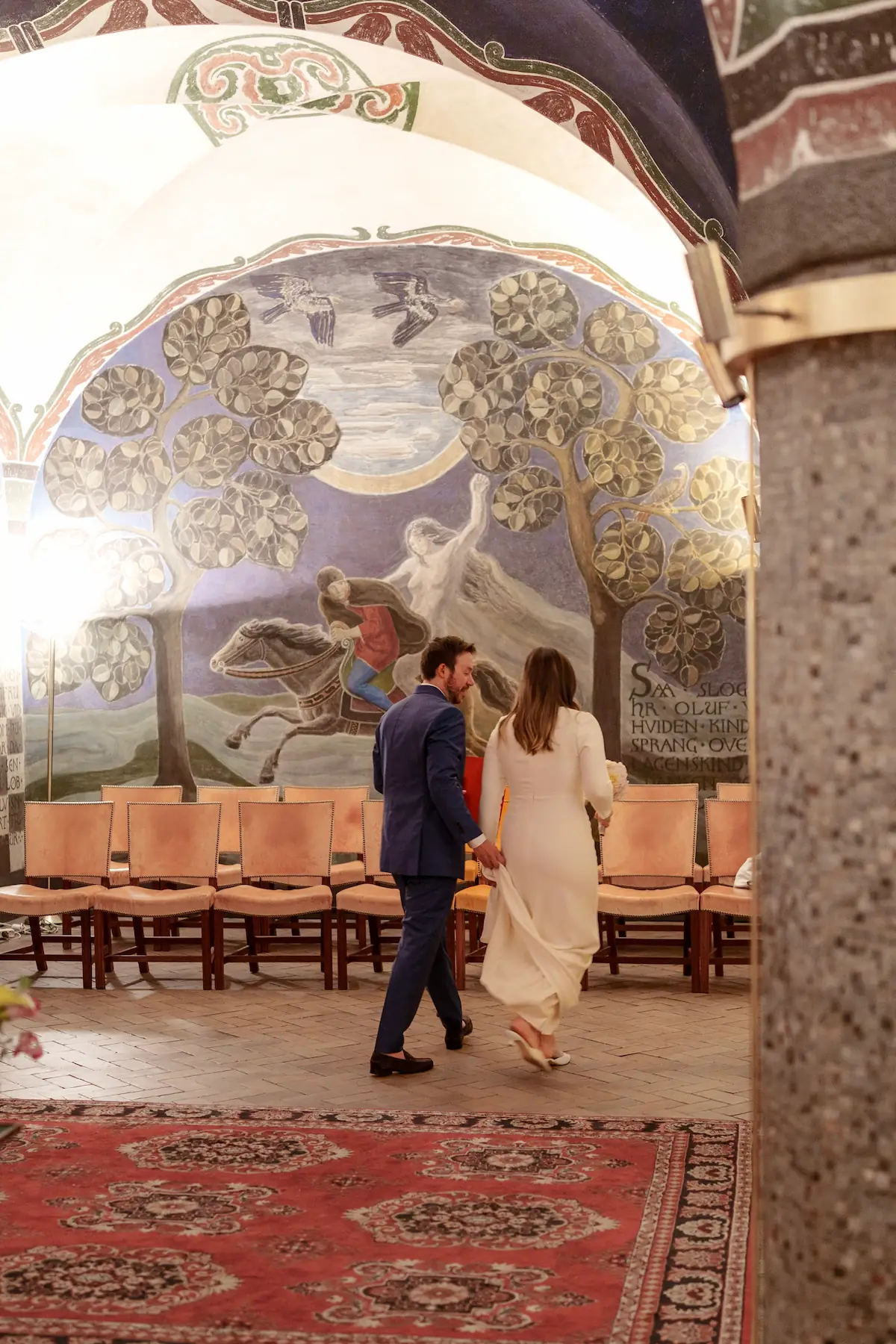Bride and groom walking through a hallway on their way to get married.