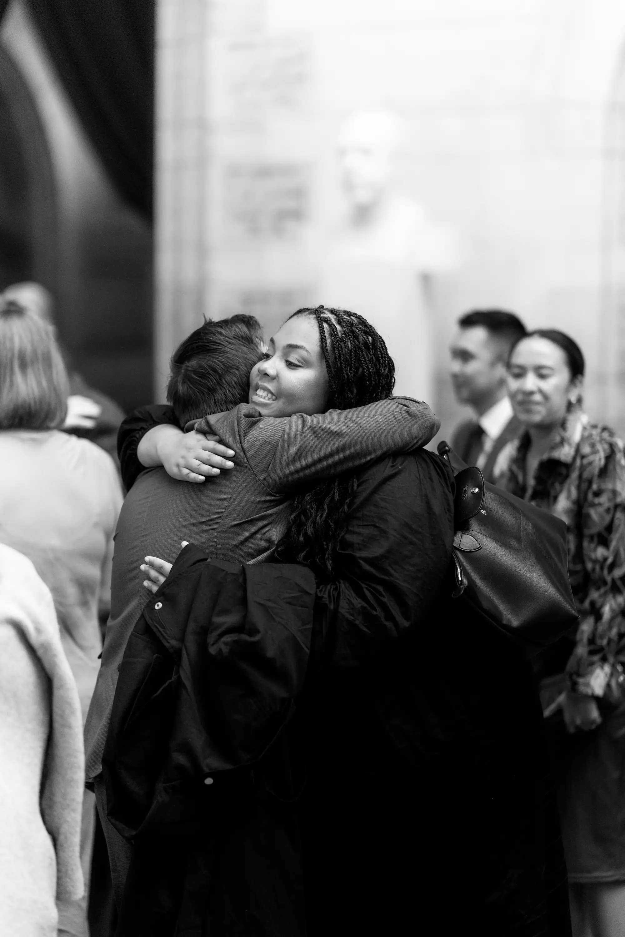 2 people embracing in a hug and greeting each other.