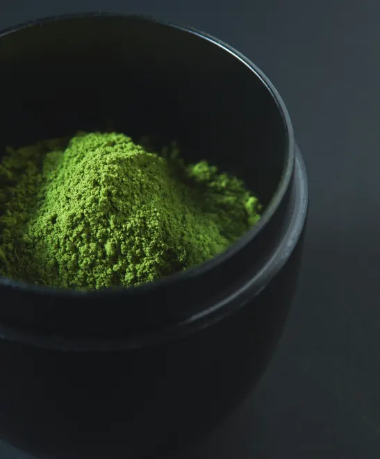Premium matcha powder in a dark bowl