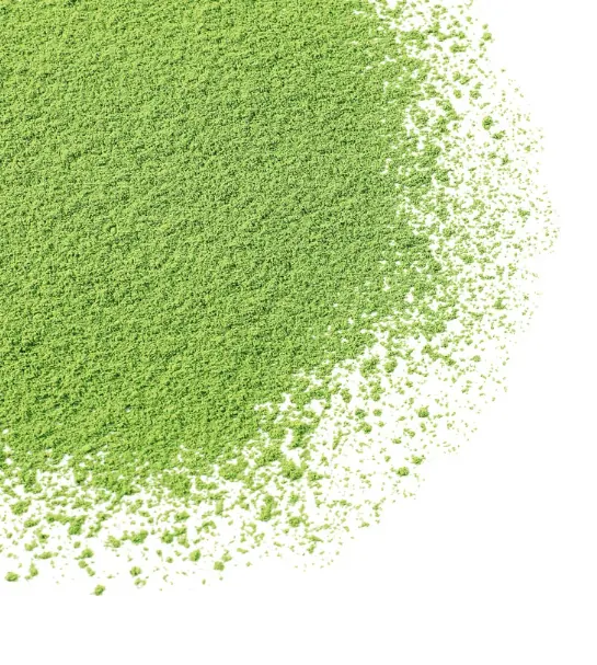 Bright green matcha powder scattered on a white background