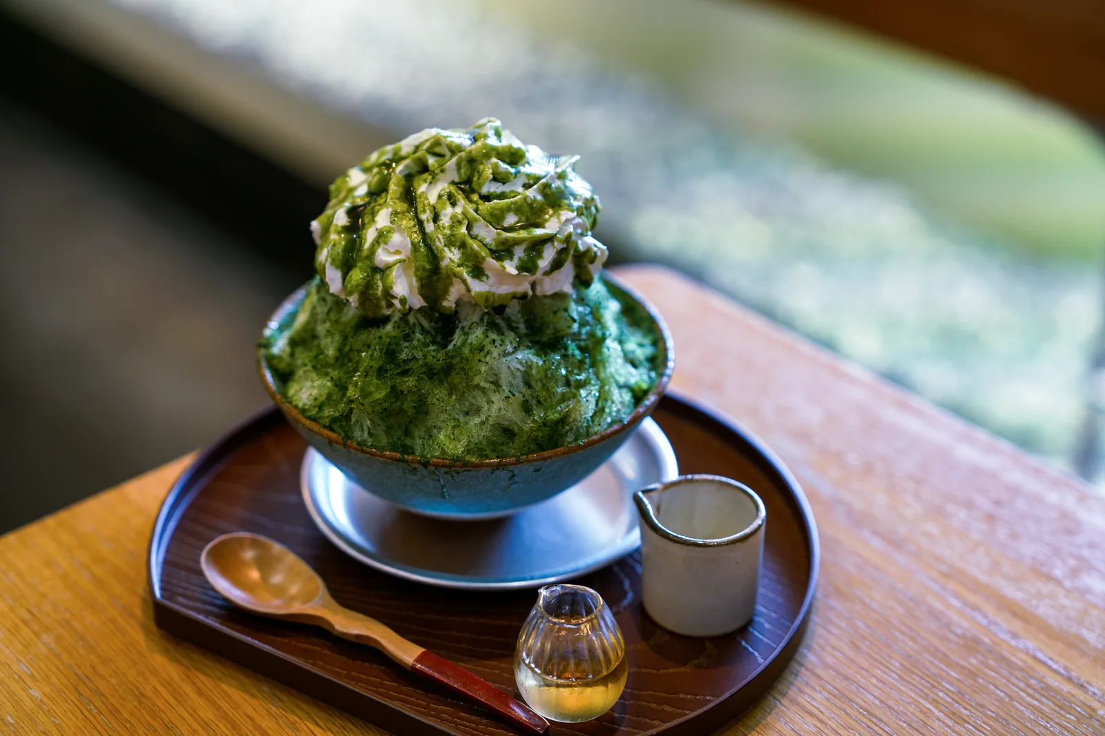 A bowl of matcha kakigori, Japanese shaved ice with matcha syrup.