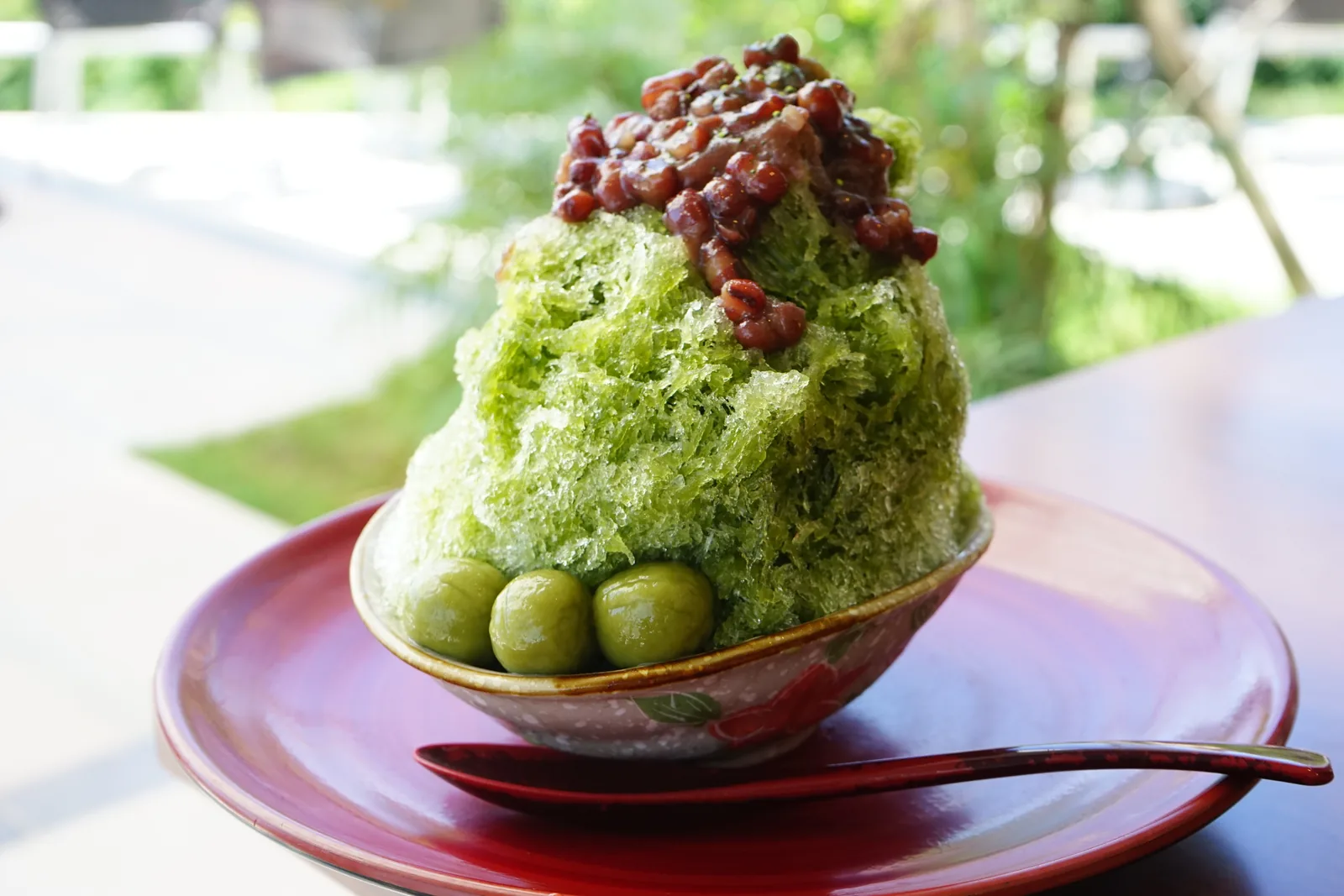A finished matcha kintoki kakigori with sweet red azuki beans.