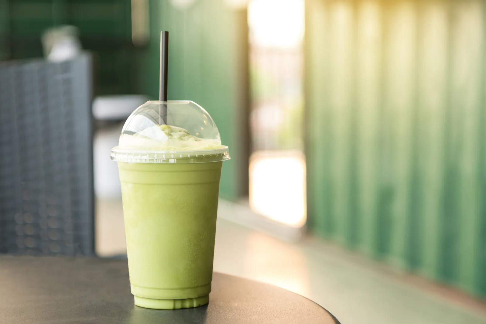 Green tea matcha smoothies in plastic cups at a coffee shop.